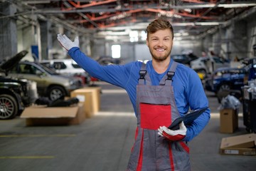 Cheerful serviceman in a car workshop