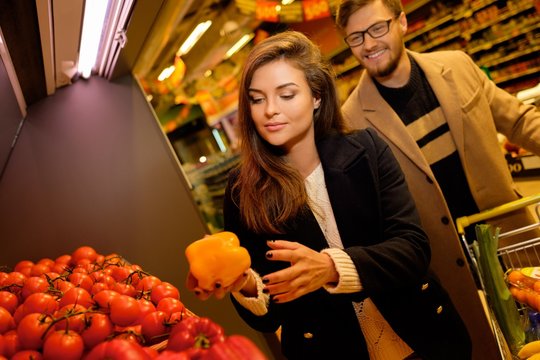 Couple choosing vegetables in a grocery store