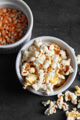 Fototapeta na wymiar Popcorn in bowls on dark background