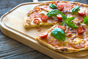 Pizza with mozzarella, tomato and basil leaves
