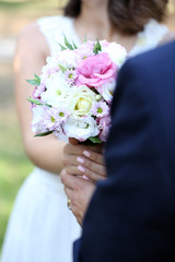 Obraz na płótnie Canvas Bride and groom holding wedding bouquet