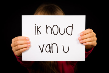 Child holding sign with Dutch words Ik Houd Van U - I Love You
