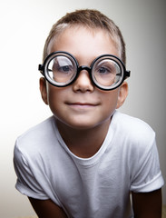 Fototapeta premium Portrait of a handsome little boy on the white wall background