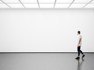 Young man walking in the empty gallery