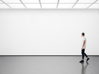 Young man walking in the empty gallery - 93830130