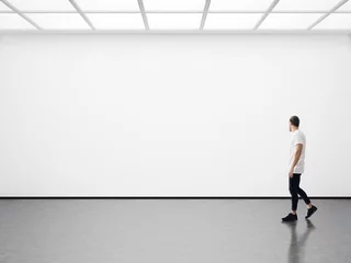 Fotobehang Young man walking in the empty gallery © SFIO CRACHO