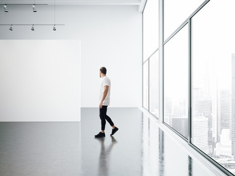 Empty gallery interior and walking young man 