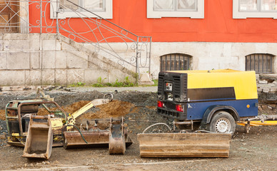 Ein fahrbarer Kompressor, ein Sandrüttler und Baggerlöffel