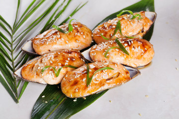 Asian clams baked with sesame sauce sushi rolls on a tropical