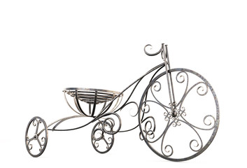 Fototapeta na wymiar Small metal decorative tricycle close-up.