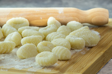 Gnocchi di patate fatti a mano, su tagliere con mattarello, gnocchi di patate su farina