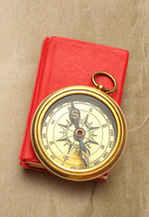 Fototapeta na wymiar Red closed book with retro compass