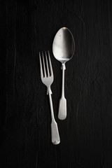 Still life photography with spoon and fork on rustic background,