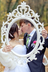 Bride and groom in forest with retro photo frame 