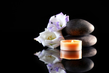 Spa stones and candles on dark background