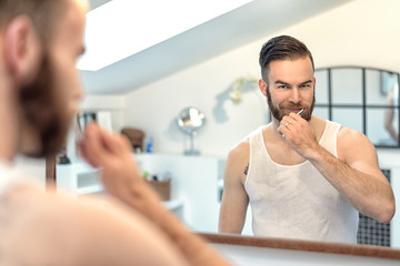 Mann mit Bart putzt seine Zähne