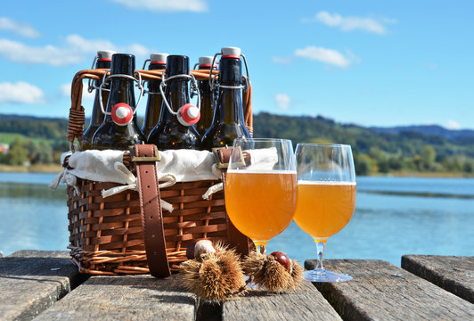 Beer bottles in the vintage basket on a wooden pier