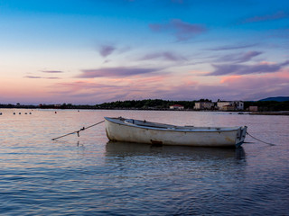 Lonely white boat on the Tuscan sea at sunset