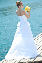 Fototapeta na wymiar Beautiful bride with bouquet on the beach restorant