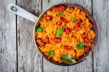 homemade braised sauerkraut with smoked sausages in a frying pan