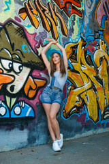Obraz na płótnie Canvas Young girl posing against wall with graffiti