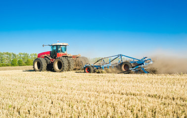 Obraz premium Ploughing heavy tractor during cultivation agriculture works at