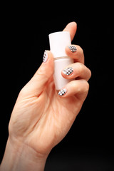 Szalony manicure, czarno biała kratka. Dłoń kobiety z paznokciami pomalowanymi w czarno biała kratkę