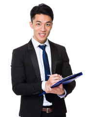 Businessman take note on clipboard