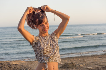 mujer haciéndose una coleta en la playa