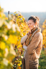 Relaxed woman winegrower standing in vineyard outdoors in autumn