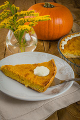 Pumpkin Pie, cake slice, vase with yellow flowers on a dark wooden background