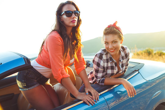 Two young girls having fun in the cabriolet outdoors