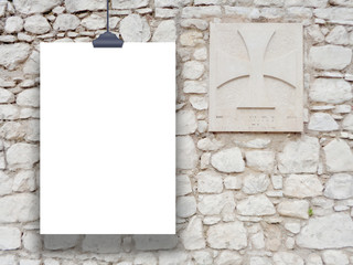 Single hanged paper sheet with clip on medieval stone wall background