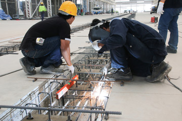 worker sitting welding structure in factory