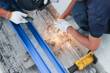 Worker welding crane railway with tools