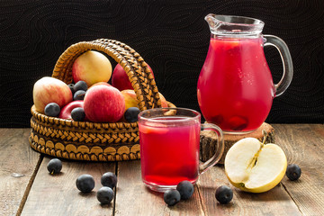 Fruit compote in a jug and mug, apples and blackthorn in a baske