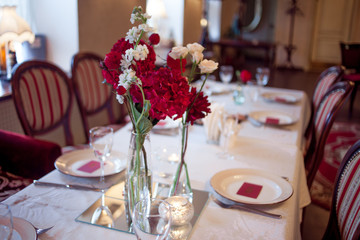 interior of the restaurant,  large table laid for  Banquet, decorated in Burgundy tones