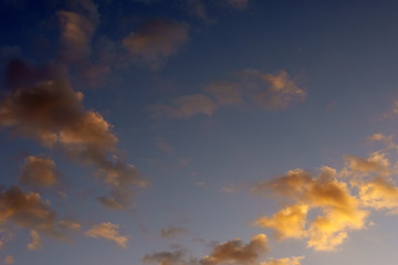 Fototapeta na wymiar Orangene Wolken / Orange scheinende Wolken bei einem Sonnenuntergang