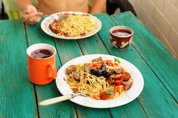Spaghetti al Pomodoro in white plates with fork on wooden turquo
