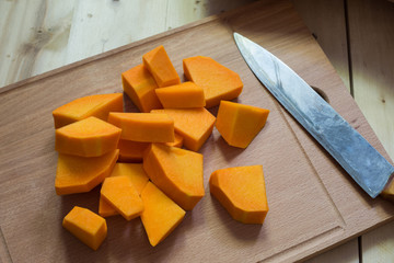 Sliced raw orange pumpkin on cutting board