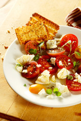 Tasty tomato and cheese salad with herbs