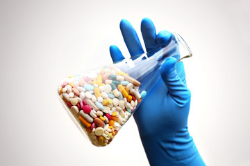 A lot of pills in the Erlenmeyer flask in the hand