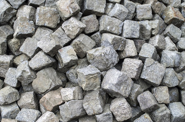 Heap of old granite used paving stones