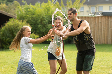 junge Familie spielt mit Wasser