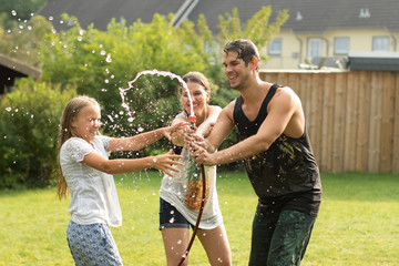 junge Familie spielt mit Wasser