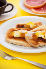 Obraz na płótnie Canvas French toast with sliced orange on yellow tablecloth
