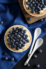 Homemade blueberry tart on black wooden table