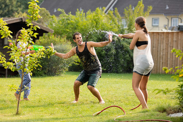 junge Familie spielt mit Wasser