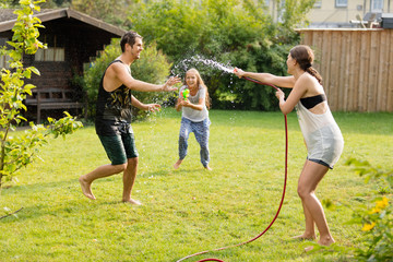 junge Familie spielt mit Wasser