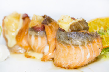 fried fish rolls with herbs and vegetables on white background